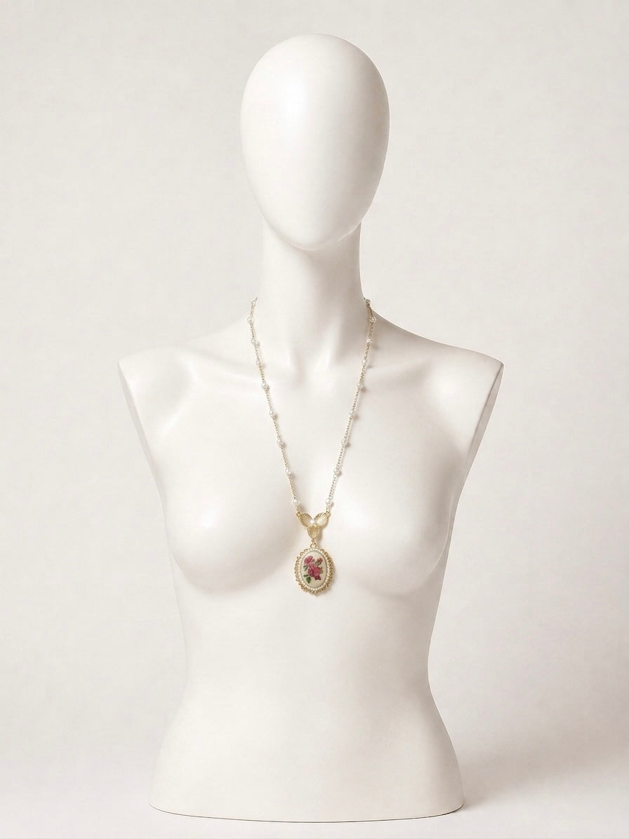 Collana lunga dorata con perle e cameo floreale