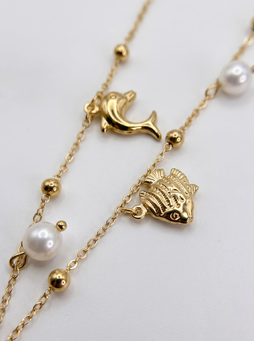 Collana dorata con charms marini e perle