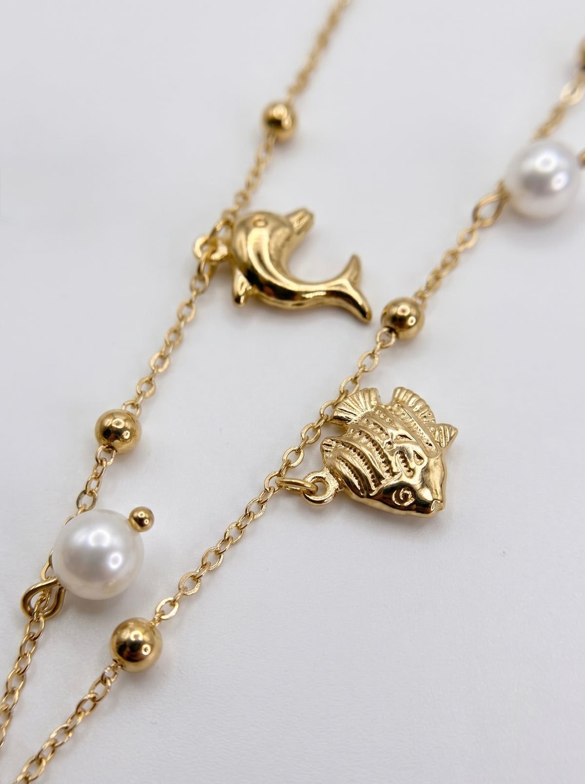 Collana dorata con charms marini e perle