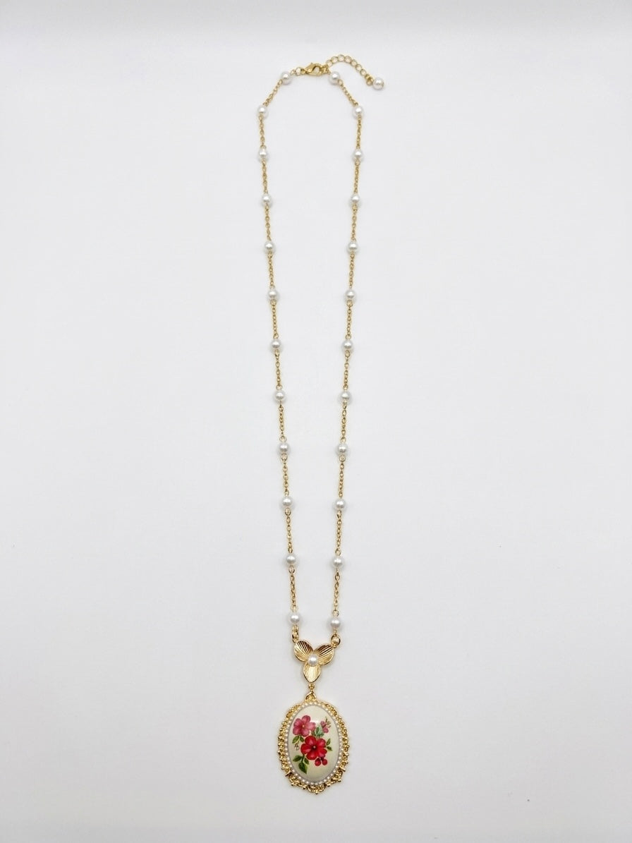 Collana lunga dorata con perle e cameo floreale