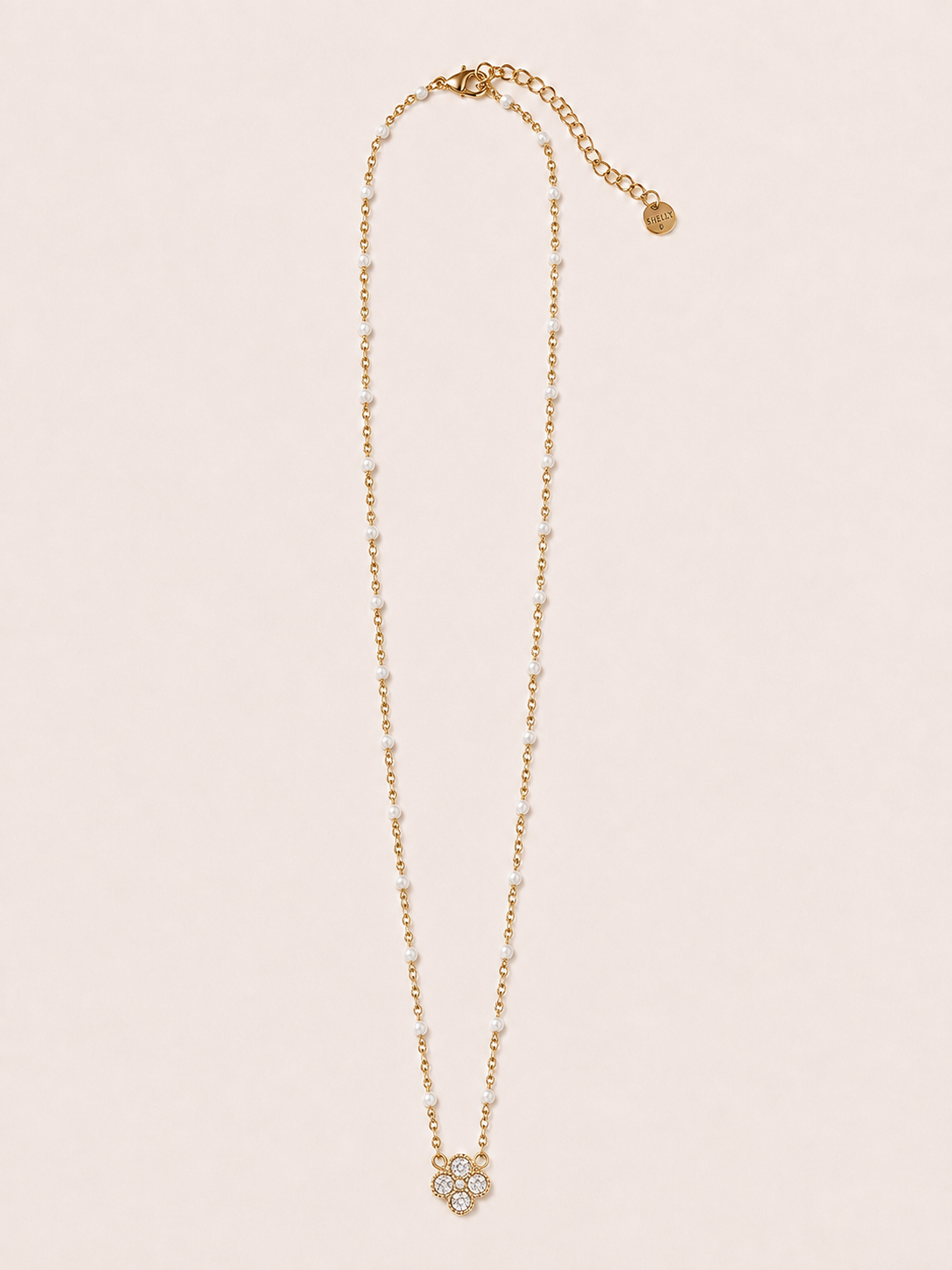 Collana dorata con fiore, cristalli e dettagli bianchi